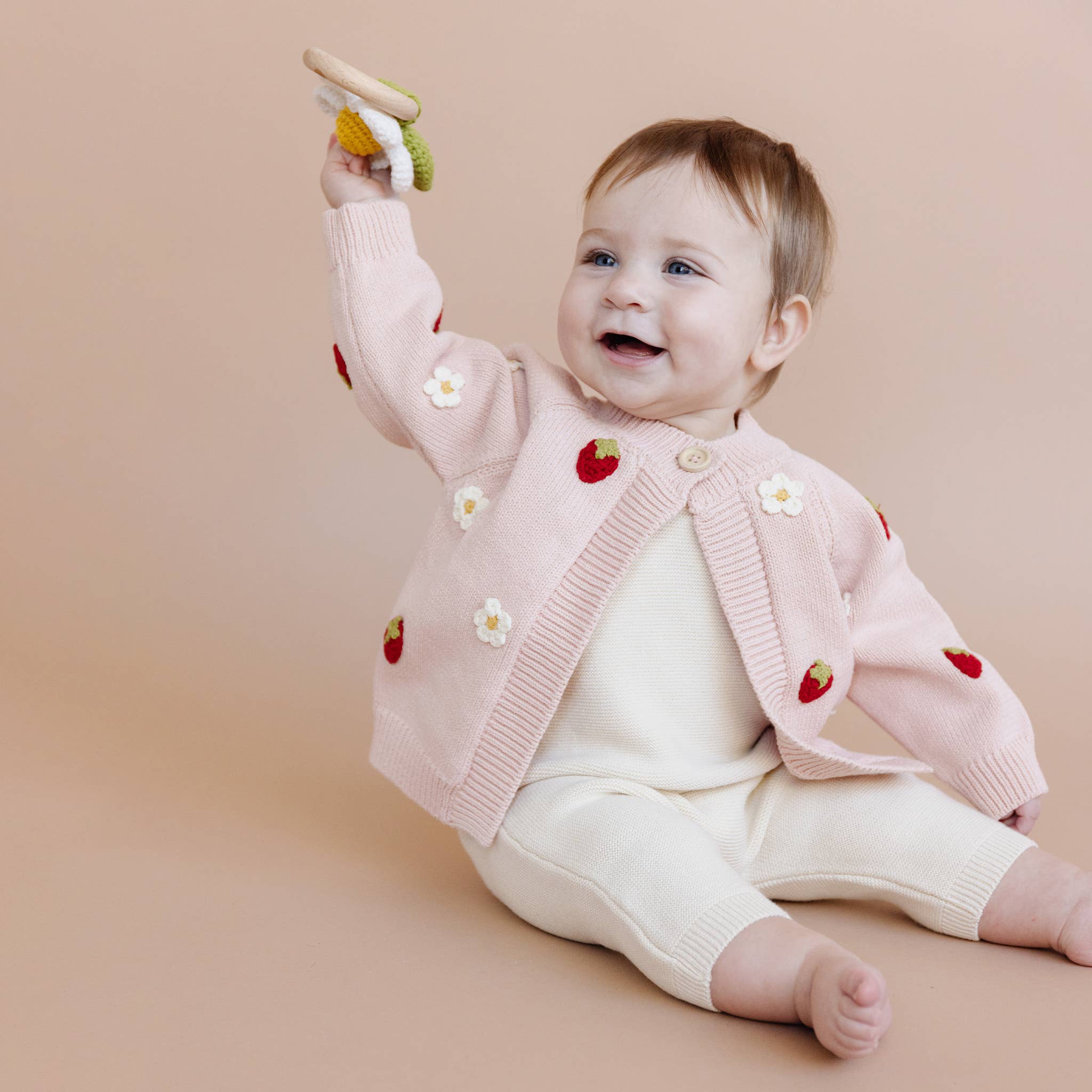 Baby wearing The Blueberry Hill Strawberry Flower Cardigan in blush