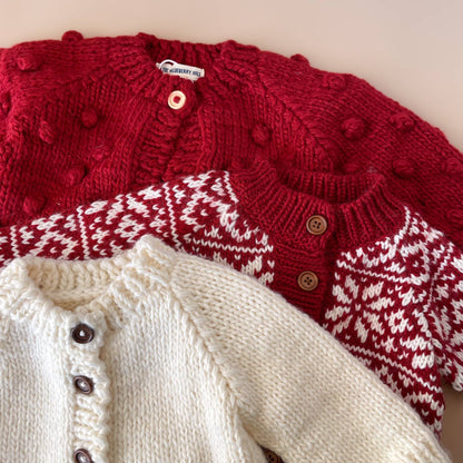 The Blueberry Hill Close-up of red Popcorn Cardigan layered with cream knitwear