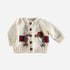 The Blueberry Hill Cream Dachshund Cardigan with a dog motif in blue and red stripes