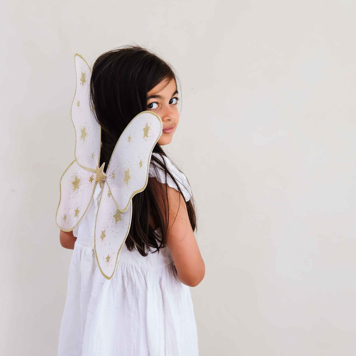 Child wearing Mimi &amp; Lula pink starry night fairy wings