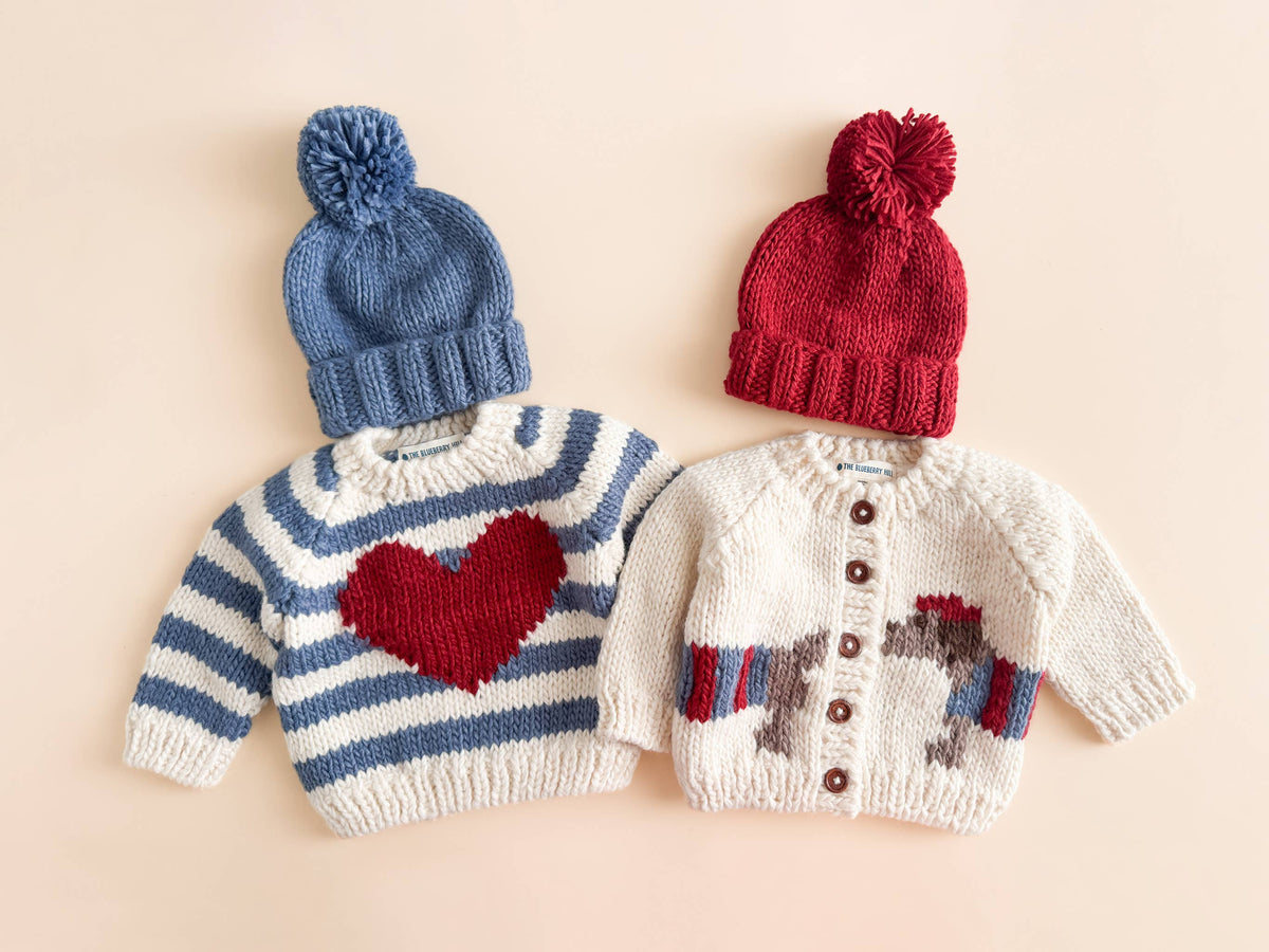 The Blueberry Hill Dachshund Cardigan and striped heart sweater with blue and red hats