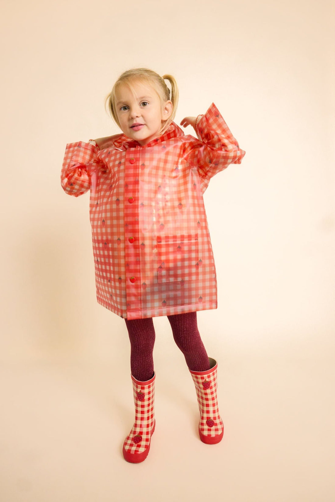 Flöss Iris raincoat in Berry Gingham shown with red rain boots