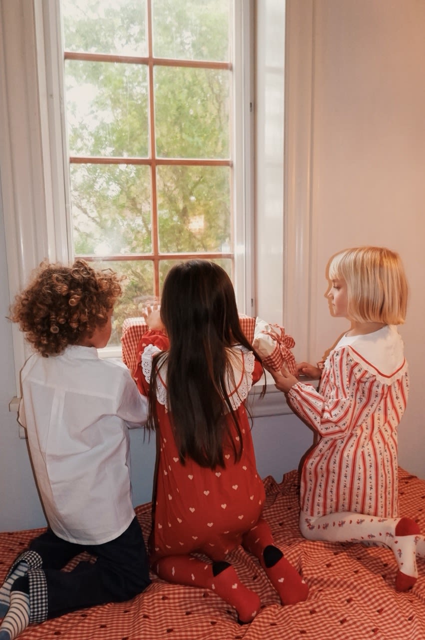 Flöss Noelle Holiday Stripe dress shown in a festive group scene
