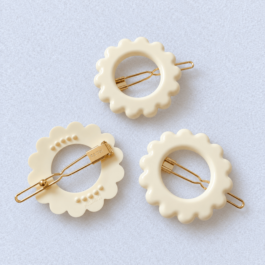 Kanel Daisy Hair Clip – Ivory Inde on a unified pale grey-white fabric background