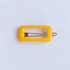 Kanel REC Hair Clip - organge on a pale white textured fabric background