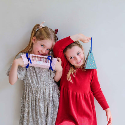 Child holding Mimi &amp; Lula Christmas tree bauble gift