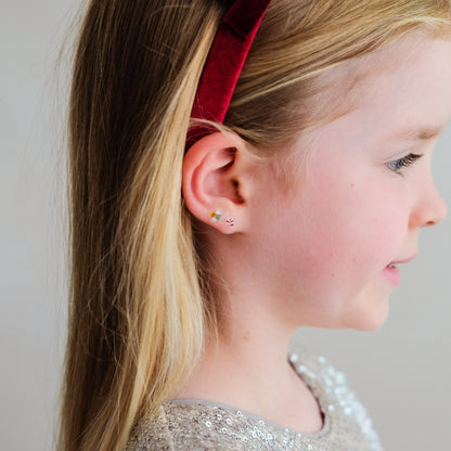 Child wearing Mimi &amp; Lula Santa stick-on earrings